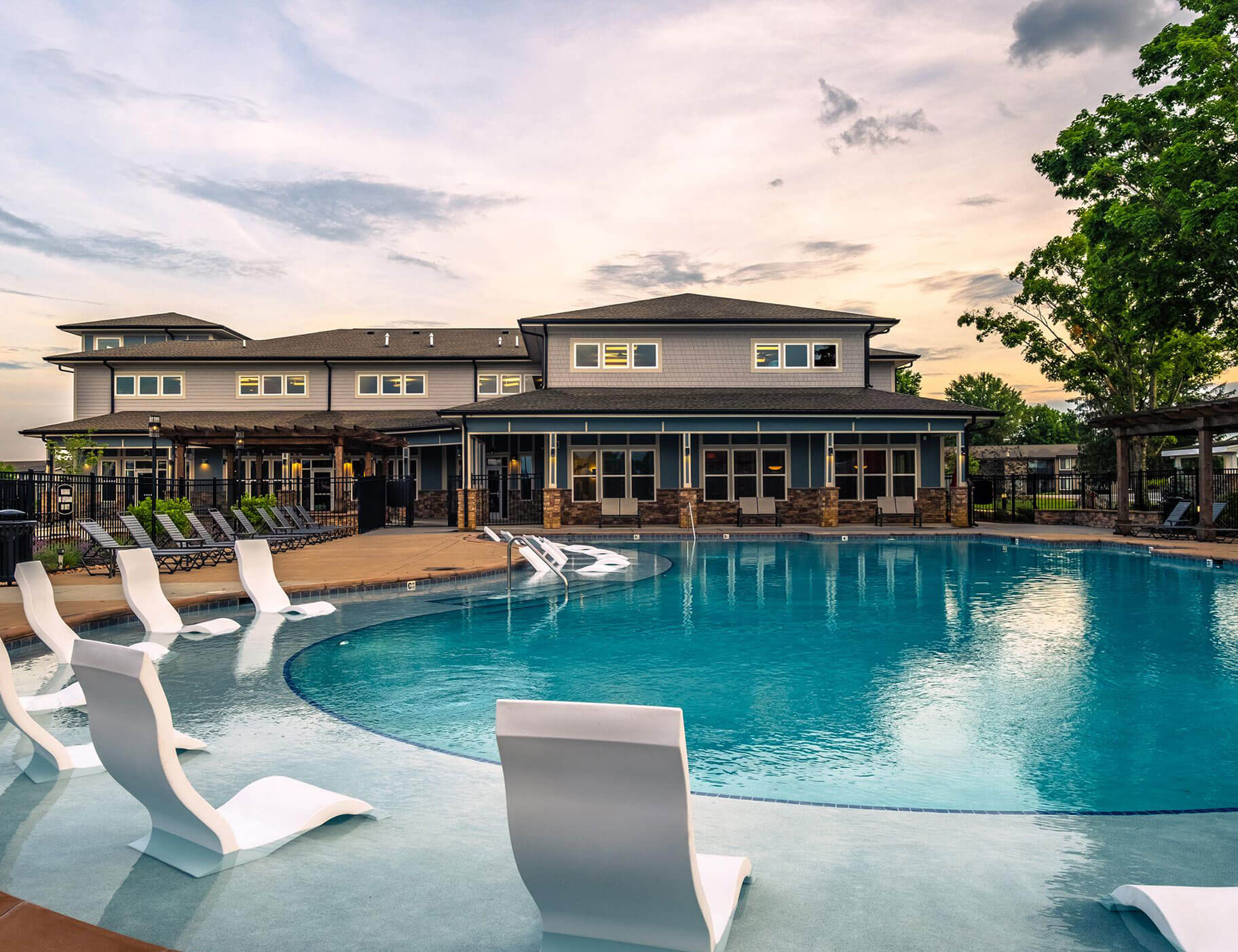 outdoor community swimming pool with white lounge chairs